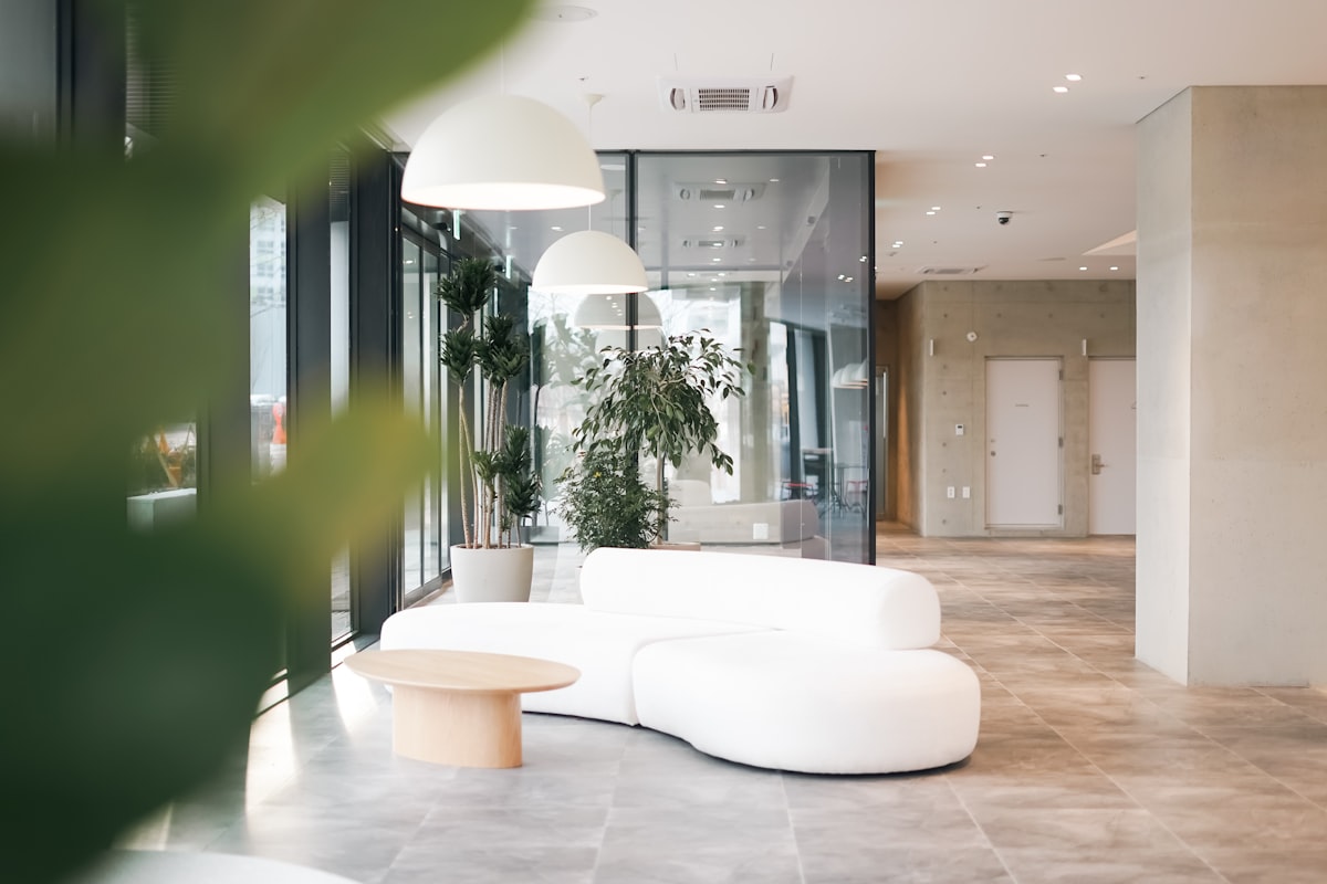 A quiet office reception with plants and a white sofa